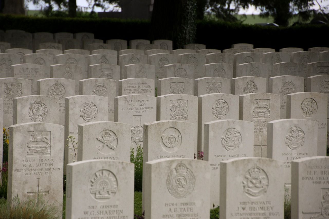 Rijen witte grafstenen op een militaire begraafplaats.