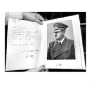 Een opengeslagen boek met handgeschreven tekst en een zwart-witportret van Hitler.