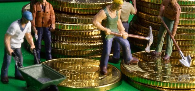Miniatuurarbeiders met gereedschap en een kruiwagen tussen stapels gouden munten.