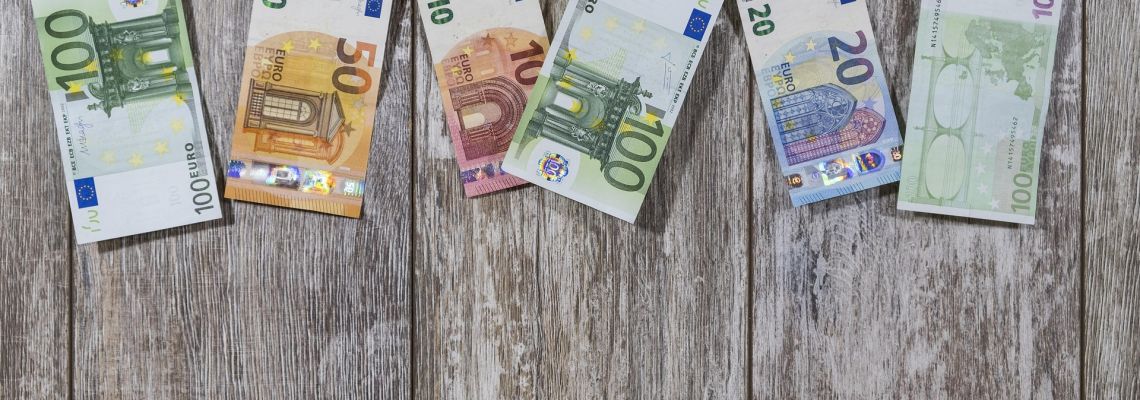 Eurobiljetten van verschillende waarden op een houten ondergrond.