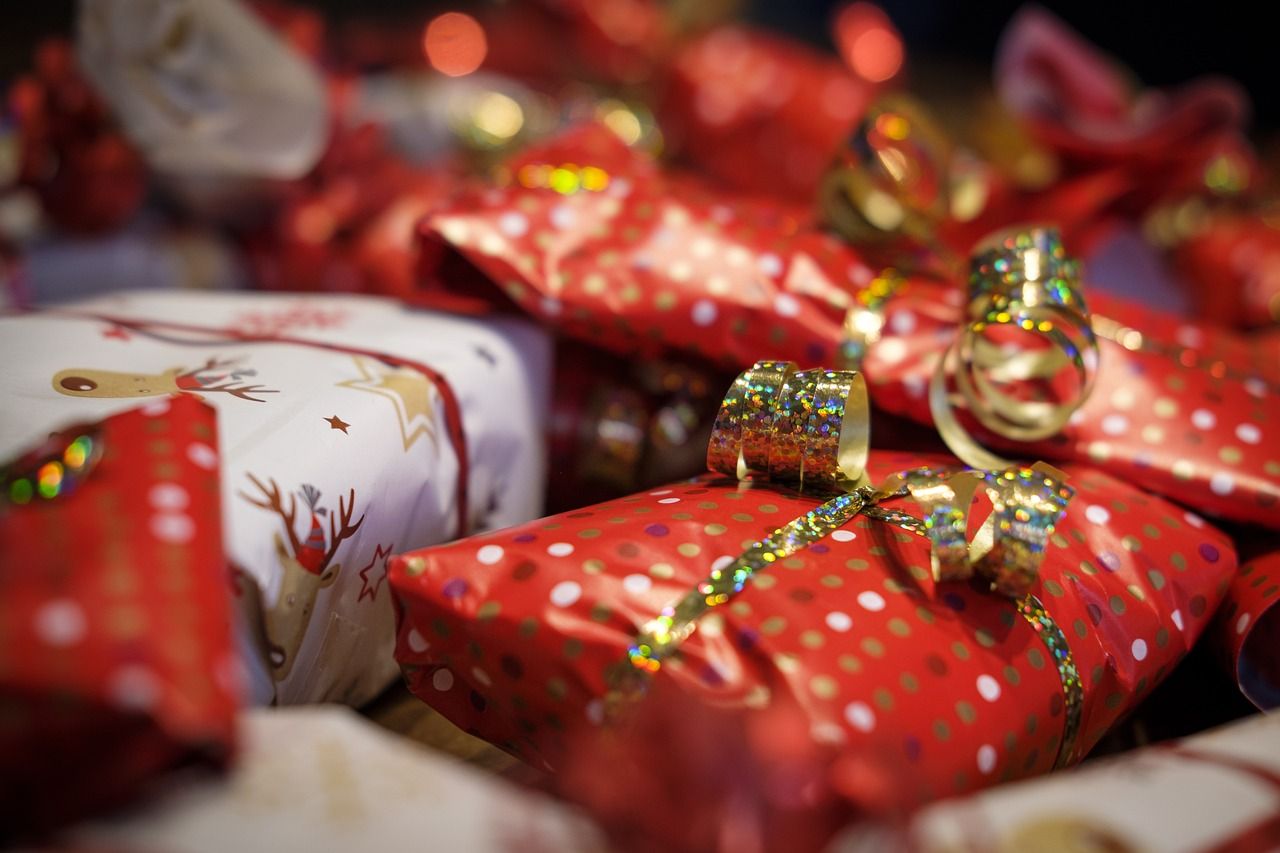 Ingepakte cadeautjes met rood en wit papier en glanzende linten.