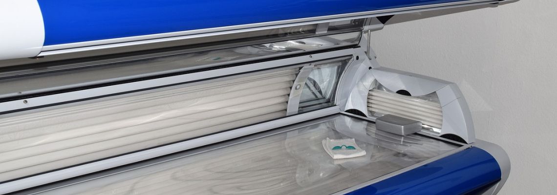 Open zonnebank met uv-lampen en een beschermbrilletje.