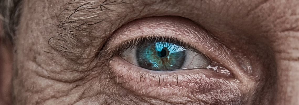 Blauwgroen oog met rimpels in de huid errond.