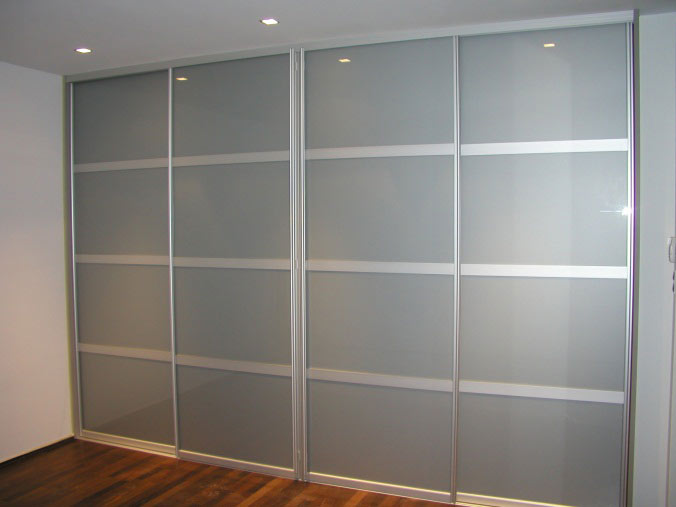 Een maatkast van vloer tot plafond met gelakte glasdeuren.