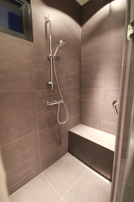 Douche met zitje en een handvat op een esthetische maar praktische plek.