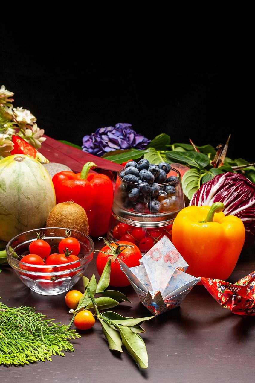 Paprika’s, tomaten, blauwe bessen en andere groenten en fruit op een tafel.