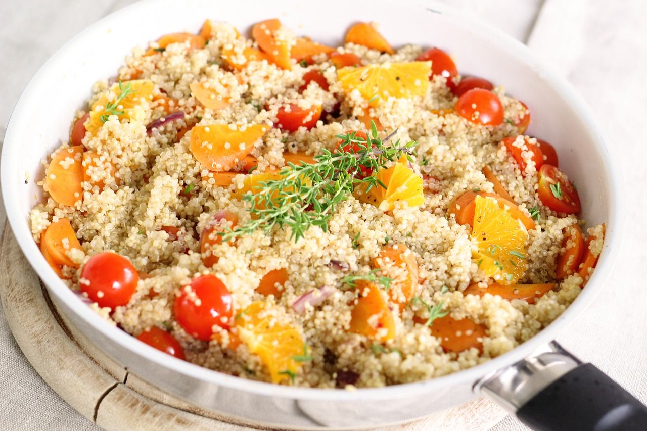 Een pan couscous met kerstomaten, stukjes groente en verse kruiden.