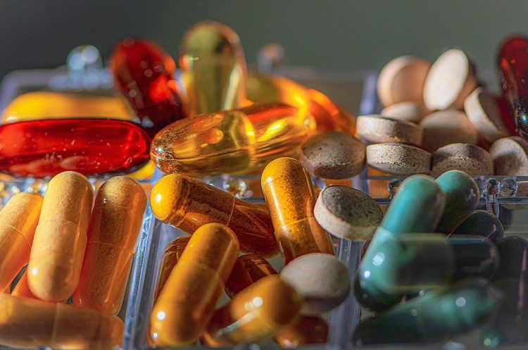 Een verzameling tabletten en kleurrijke capsules in verschillende vormen en maten.