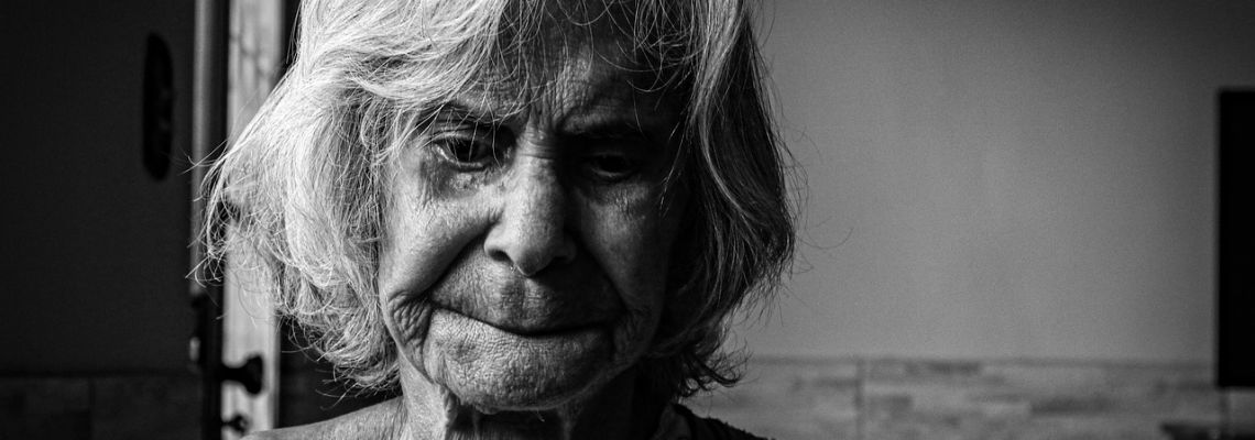 Zwart-witportret van een oudere vrouw met grijs haar en rimpels.