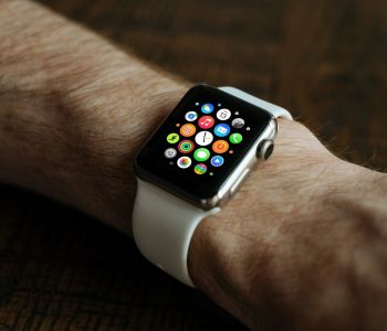 Een smartwatch met kleurrijke appicoontjes aan een pols.