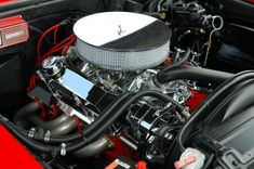 Blinkende motor met verchroomde onderdelen onder de open motorkap van een auto.
