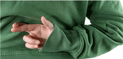 Persoon in een groene trui houdt twee vingers gekruist achter de rug.