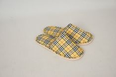 Een paar gele pantoffels met een ruitjespatroon.