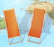 Twee rood-geel gestreepte ligstoelen op een wereldkaart.