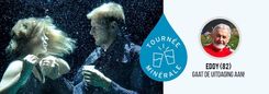 Een man en een vrouw onder water naast het logo van Tournée Minérale en een rond portret van een oudere man.