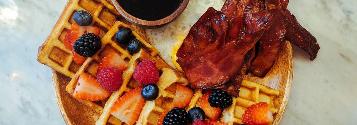 Wafels met aardbeien, frambozen, blauwe bessen, bramen en gebakken spek.
